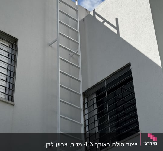 סולם מתכת לבן על קיר חיצוני של בניין